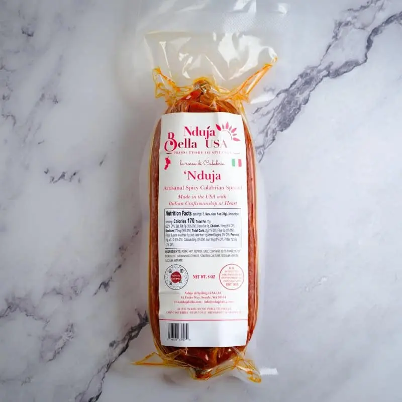 Nduja Bella spicy Calabrian spread sausage in clear packaging, ready for authentic Italian cuisine.